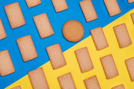 A top view shot of rectangular cookies and one circular on a blue and yellow surface