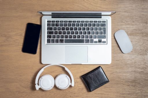 A top view of a wooden desk with work equipments