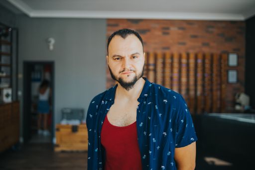 A straight portrait of a Bosnian male standing in a room.
