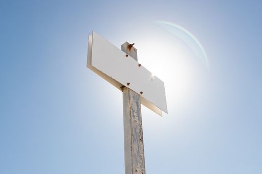 Blank sign against blue sky. Aged metallic post sign. Template Mock up