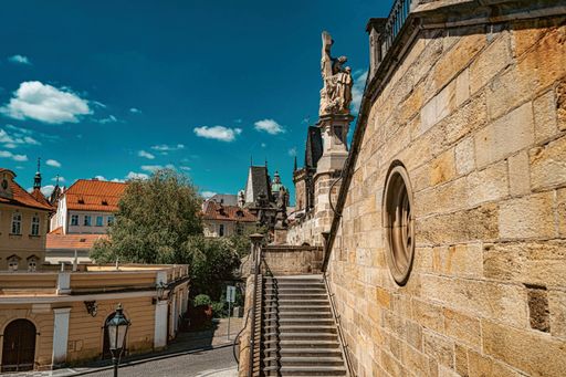 Scenic view of historic architecture and statues in Prague under a clear blue sky, showcasing European urban charm.