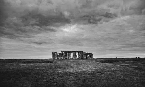 Black and white image of Stonehenge under a dramatic cloudy sky in Wiltshire, England.