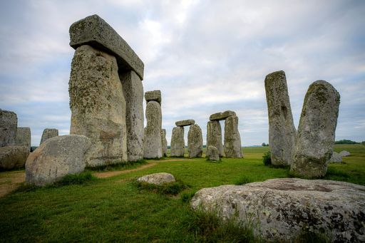 Iconic Stonehenge stones under a cloudy sky in Wiltshire, England, showcasing the ancient monument's grandeur and mystery.