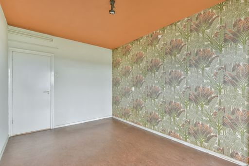 An empty laminated room with no furniture and windows