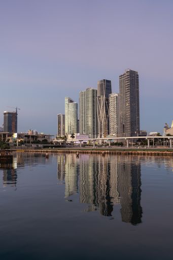 A vertical shot of skyscrapers in a port over the sea.