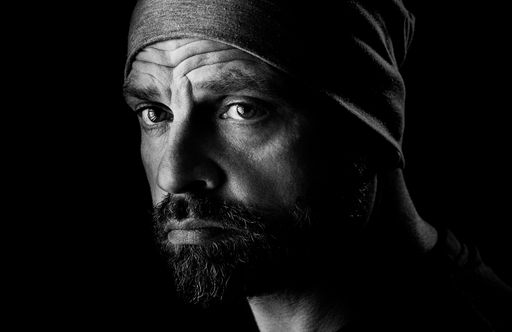 A grayscale shot of a portrait of a handsome attractive bearded anxious man with a wrinkled forehead