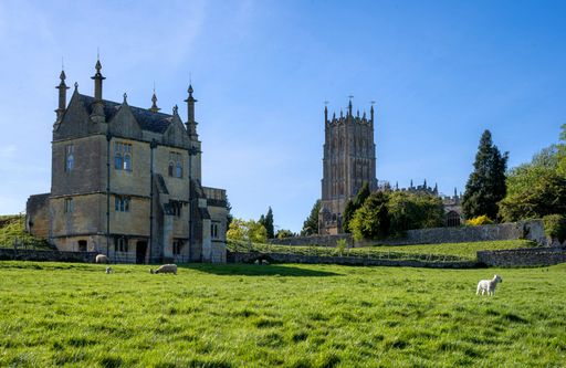 A scenic view of St James Church on Cotswold Way with grazing sheep in England