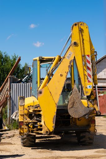 A grungy old yellow excavator in a construction area
