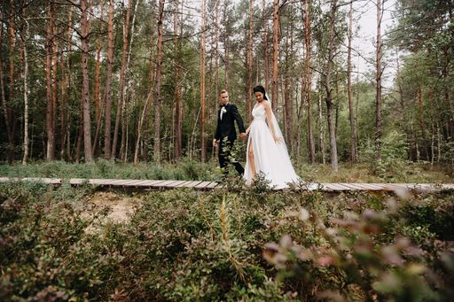 A beautiful view of a Caucasian (white) bride and groom together in the forest in Lithuania
