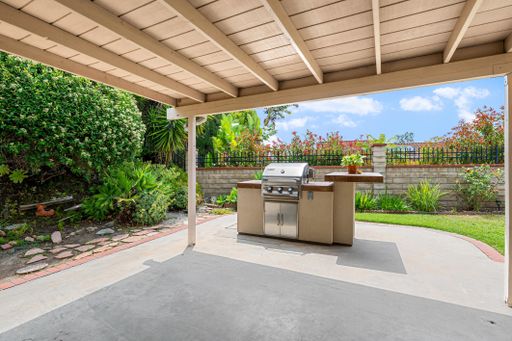 Single-level California home featuring a spacious kitchen, shaded patio, landscaped yard, and bright living spaces.