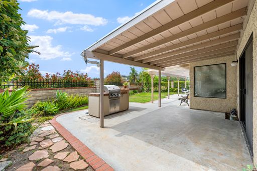 Single-level California home featuring a spacious kitchen, shaded patio, landscaped yard, and bright living spaces.