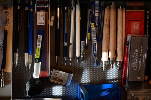 A drawer filled with neatly arranged pencils, brushes, and colorful tools