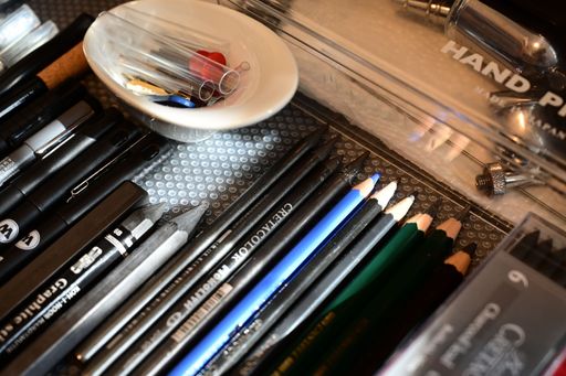 Neatly arranged pencils, brushes, and colorful tools nestled inside a well-used drawer.