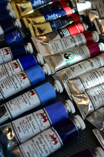 An assortment of colorful oil paint tubes displayed on a textured surface, showcasing various hues and brands.