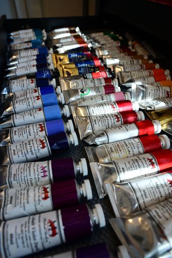 An assortment of colorful oil paint tubes displayed on a textured surface, showcasing various hues and brands.