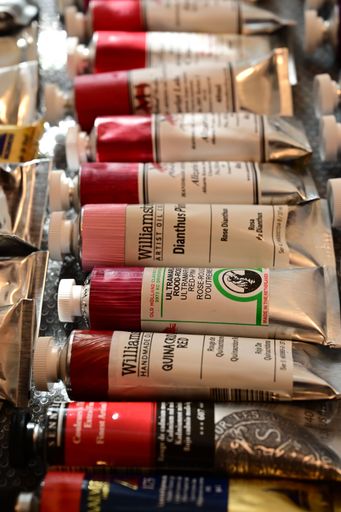 An assortment of colorful oil paint tubes displayed on a textured surface, showcasing various hues and brands.