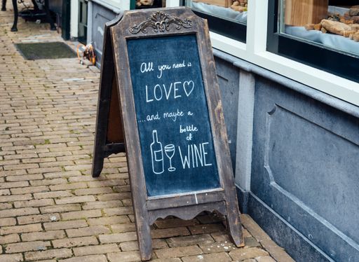 Funny message handwritten with chalk in the slate of a wine bar
