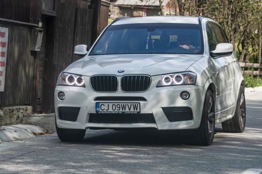A front view of a white BMW driving on asphalt road. Bucharest, Romania, 2020