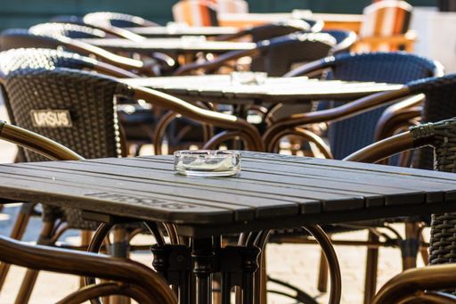 A selective focus shot of an empty table with chairs at a local outdoor restaurant in Romania