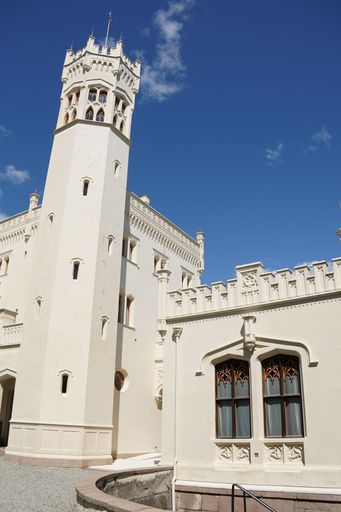 Historic white castle with ornate architecture under a clear blue sky in a sunny day.