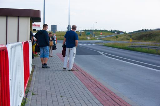 A people waiting by a public transport bus stop