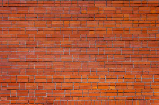 Square and rectangular red bricks form a wall pattern. Abstract vintage background.