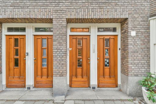 A closeup of four wooden entrance doors to a residential building