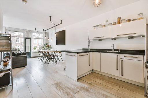 A modern white kitchen combined with a living room