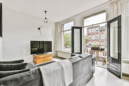 A spacious furnished living room with an exit to an exterior balcony
