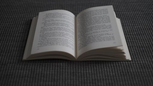A top view of an open book on a gray surface