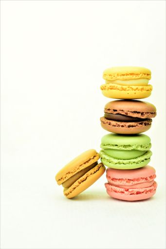 A vertical shot of colorful macaroon biscuits isolated on the white background