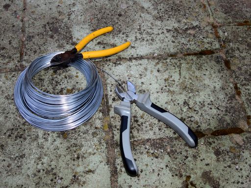 A top view of two pliers and wires on the ground