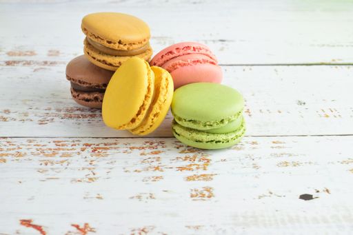A selective focus shot of colorful macaroon biscuits on a wooden surface