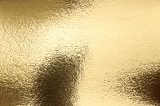 Close-up of a textured gold foil surface creating a luxurious and shiny background.