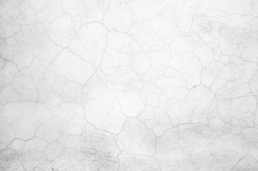 Close-up of a cracked white wall texture, ideal for backgrounds or design projects.