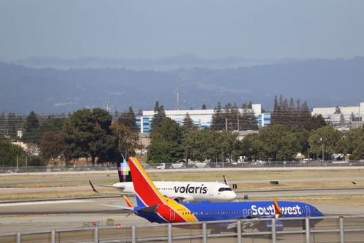 A ground view of Volaris and Southwest airplanes lined up on the tarmac under clear skies.