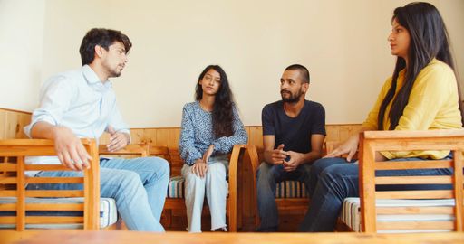 A shot of four young South Asian friends in India sitting and talking