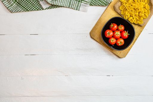 A top view of beautiful tasty Italian pasta and cherry tomatoes on a cutting board; copy space
