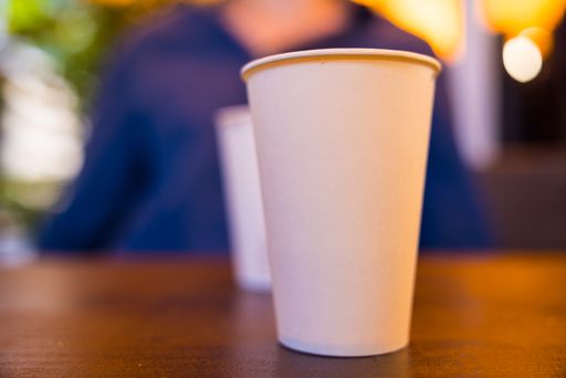 A closeup shot of a white paper beverage cup