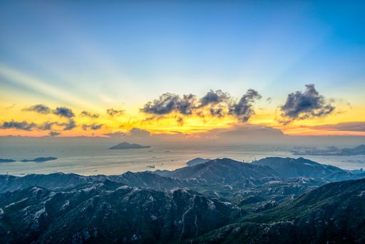 A high angle shot of the mountains under the breathtaking lights in the cloudy sky