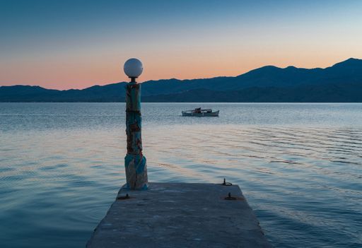 A beautiful view of a sea with hills background during the suns