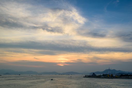 A low angle shot of the breathtaking cloudy sky over the calm and beautiful ocean