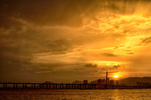 A low angle shot of the breathtaking sunset in the sky over the buildings and the bridge