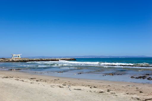 A wide angle shot of the beach under a blue sky