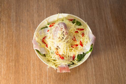 A top view of a bowl with a salad on a wooden table