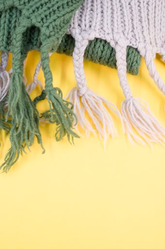 hand knitted soft wool on a yellow background with copy space