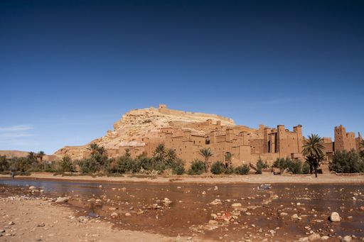 The Ait Benhaddou surrounded by palm trees under the sunlight at daytime in Morocco