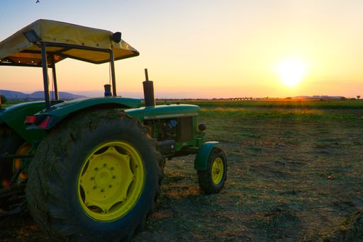 tractor John Deere at the beautiful sunset of the Thessalian plain, agricultural machinery, Farsala city, Greece