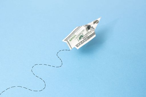 flying dollar airplane bill and its path isolated on blue background
