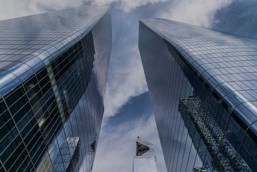 Low angle view of New York City skyscrapers against a daytime sky.